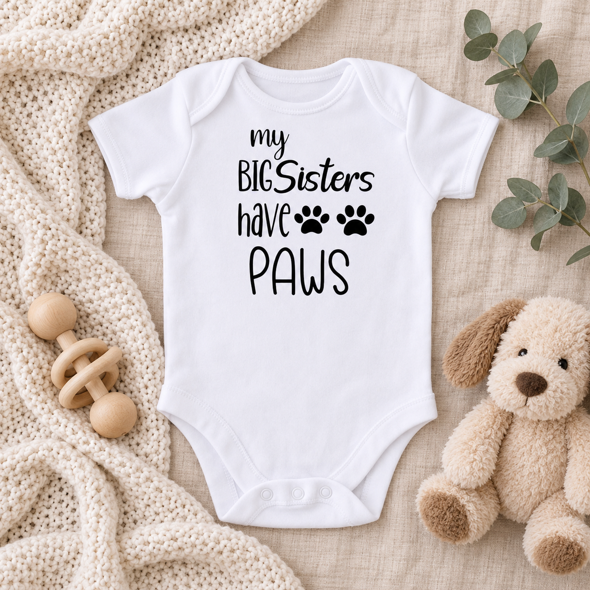 My Big Sisters Have Paws baby bodysuit neutral nursery flat lay