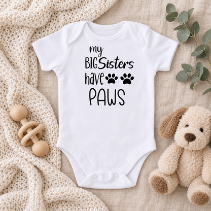 My Big Sisters Have Paws baby bodysuit neutral nursery flat lay